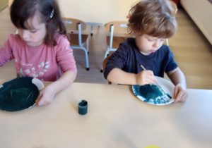 Dzieci maluja papierowe talerze